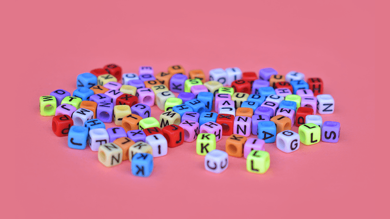 Coloured letters scattered on a red background