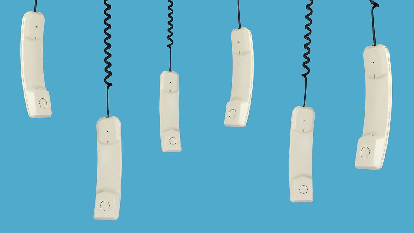 Corded phones hanging on a blue background